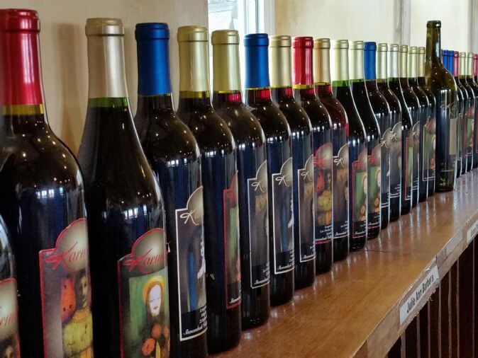 A row of Karmere wine bottles on a shelf.