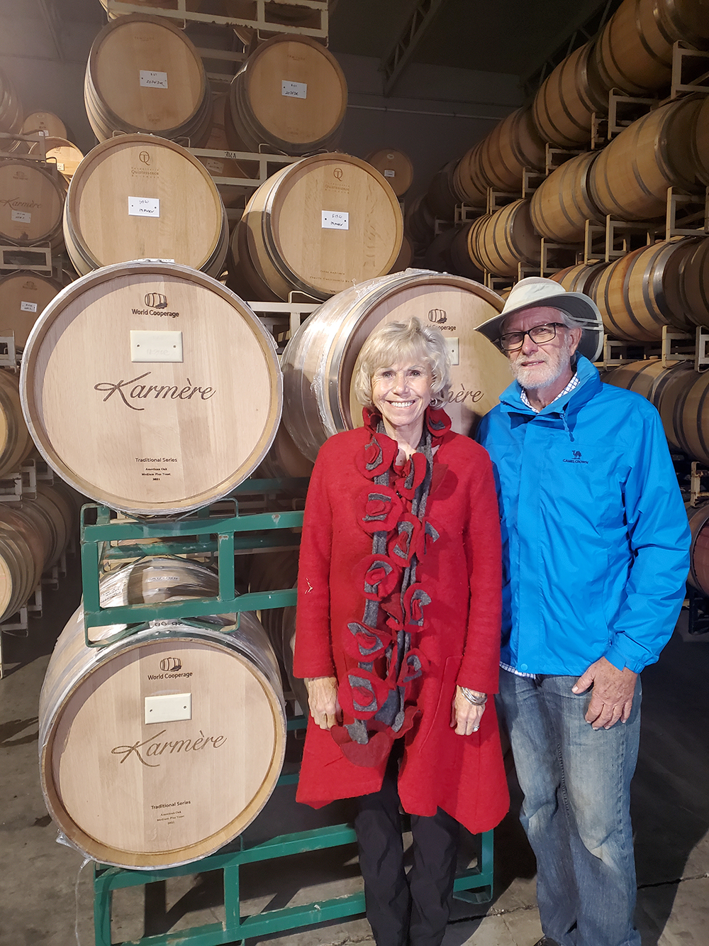 Two people beside wine barrels